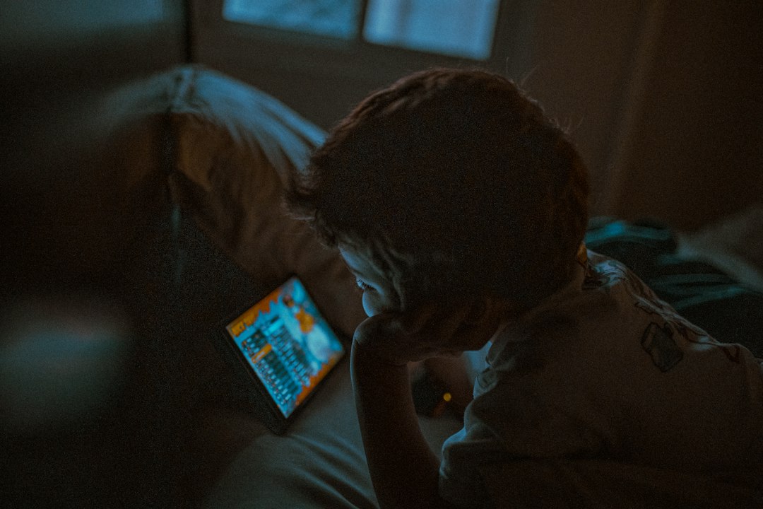 Kind in dunklem Raum mit Tablet